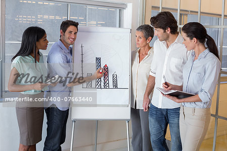 Businessman explaining graph to coworkers in the office