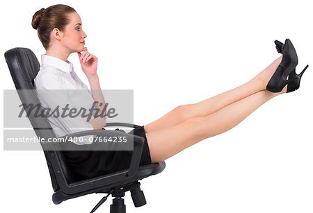 Businesswoman sitting on swivel chair with feet up on white background