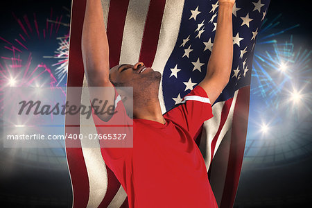 Excited handsome football fan cheering against fireworks exploding over football stadium and usa flag