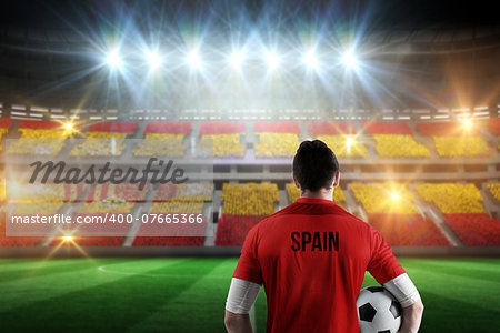 Spain football player holding ball against stadium full of spain football fans