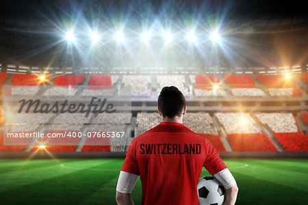 Swiss football player holding ball against stadium full of swiss football fans