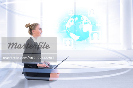Businesswoman using laptop against bright room with columns