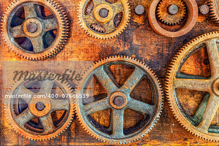 Closeup image of rusted gears hanging on the wall of an abandoned workshop