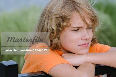 teen sitting on a bench worried about his actions