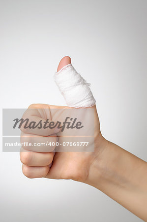 Injured painful thumb with white bandage