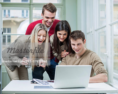 Happy business people using laptop in meeting