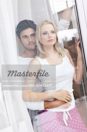 Loving young couple looking through hotel window