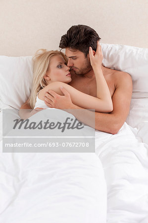 Young couple cuddling in bed