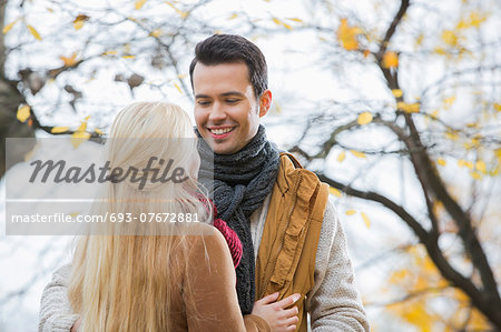 Young man looking at woman in park during autumn