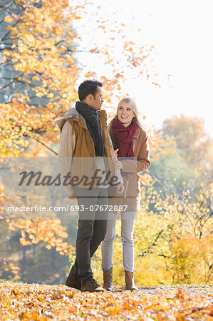 Full length of couple walking in park during autumn