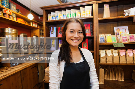 Portrait of female salesperson smiling in coffee shop