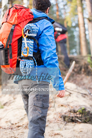 Rear view of male hiker with backpack standing in forest
