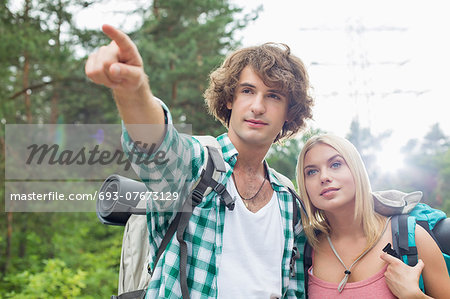 Male hiker showing something to woman in forest