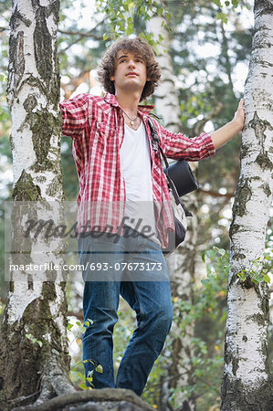 Young male hiker standing in forest