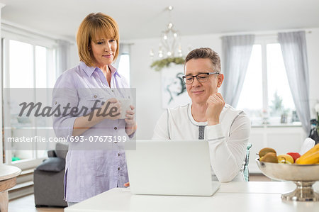 Mature couple using laptop at home