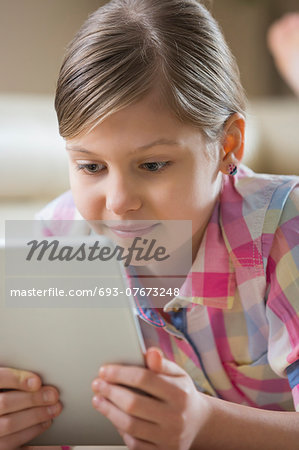 Close-up of girl using digital tablet at home