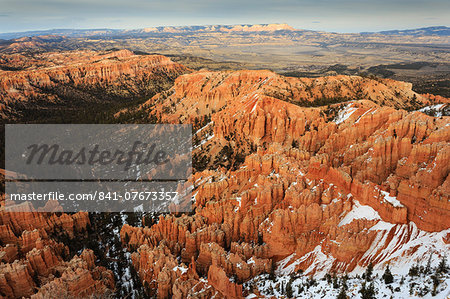 Hoodoos, trees and distant view with snow on a cloudy late winter afternoon, Bryce Point, Bryce Canyon National Park, Utah, United States of America, North America