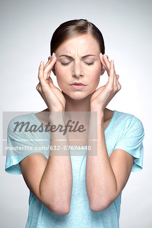 Young woman with headache holding head