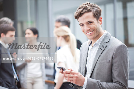 Businessman using cell phone while on the move