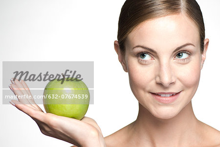 Young woman holding up green apple