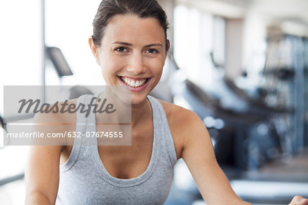 Young woman using exercise machine at gym