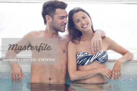 Young couple in pool together, portrait