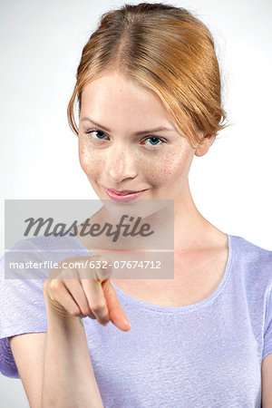 Young woman pointing at viewer
