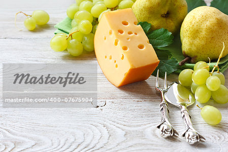 Delicious cheese and fruits on a wooden board. Food ingredients background. Selective focus.