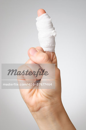 Injured painful finger with white gauze bandage