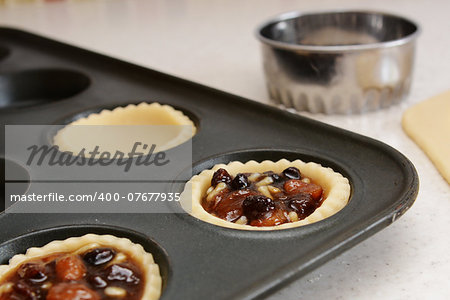 Closeup of pastry case filled with traditional mincemeat, with cutter beyond