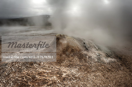 Fumarole in the geothermal area Hveravellir, central Iceland. The area around is layered and cracked.