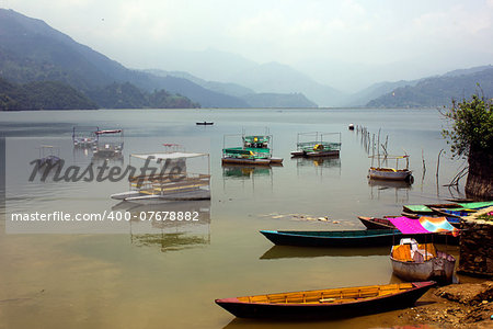 Fewa Lake in Pokhara, Nepal, bounded by a range of hills at the horizon.
