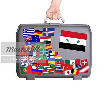Used plastic suitcase with lots of small stickers, large sticker of Syria