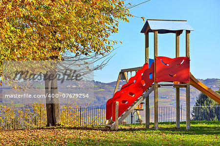 Lone children's slide on empty playground in autumn in small town of Diano D'Alba, Italy.
