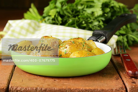 tasty baked potatoes with herbs in the pan