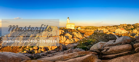 Rocky ocean coastline panorama with lighthouse at sunset, Sardinia, Italy