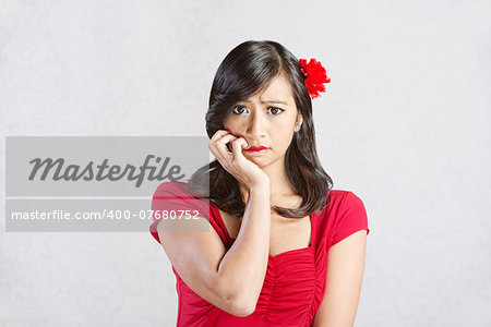Stressed out young Hispanic female in red