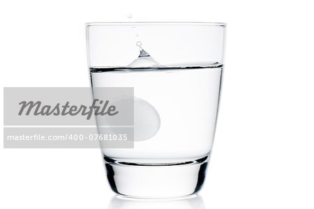 medical tablet dropped into the water on white background