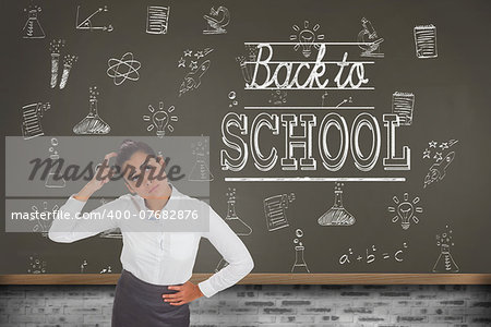 Worried businesswoman against blackboard on wall