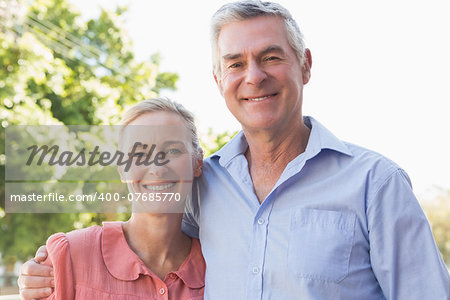 Senior couple smiling at the camera together on a sunny day