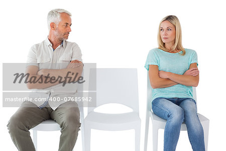 Unhappy couple not speaking to each other on white background