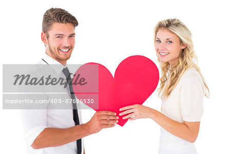Attractive young couple holding red heart on white background