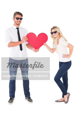 Cool young couple holding red heart on white background