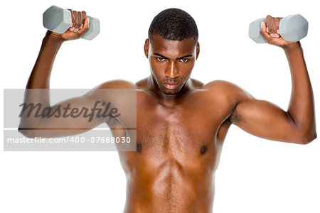 Determined fit shirtless young man lifting dumbbells over white background