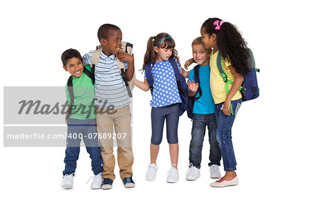 Cute schoolchildren smiling at camera and wearing backpacks on white background