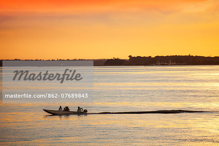 South America, Brazil, Amazon, Amazonas, Manaus, a family in a speedboat on the Rio Negro near Manaus at sunset