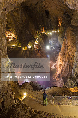 Slovenia, Karst Region, Skocjan. A tourist looks into the Muller Hall - the huge main chamber in Skocjan Caves Park, a UNESCO World Heritage Site. (MR).