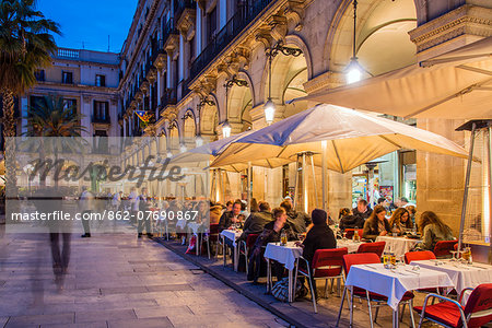 Night view of an outdoor restaurant cafe with people seated at tables, Placa Reial  or Plaza Real, Barcelona, Catalonia, Spain