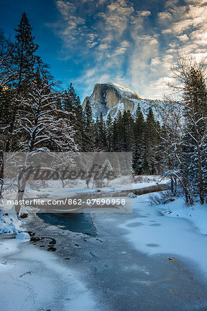 Winter view over icy Tenaya creek with Half Dome mountain behind, Yosemite National Park, California, USA