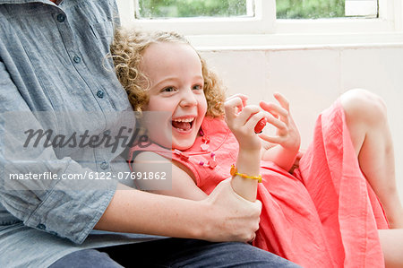 Girl laughing in Mum's arms